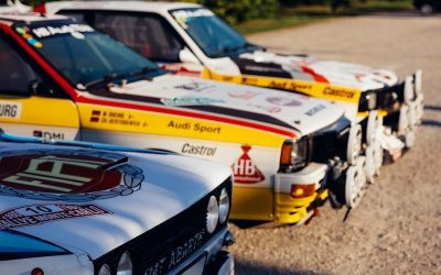un groupe de voitures de Rallye garées les unes à côté des autres dans un parking.