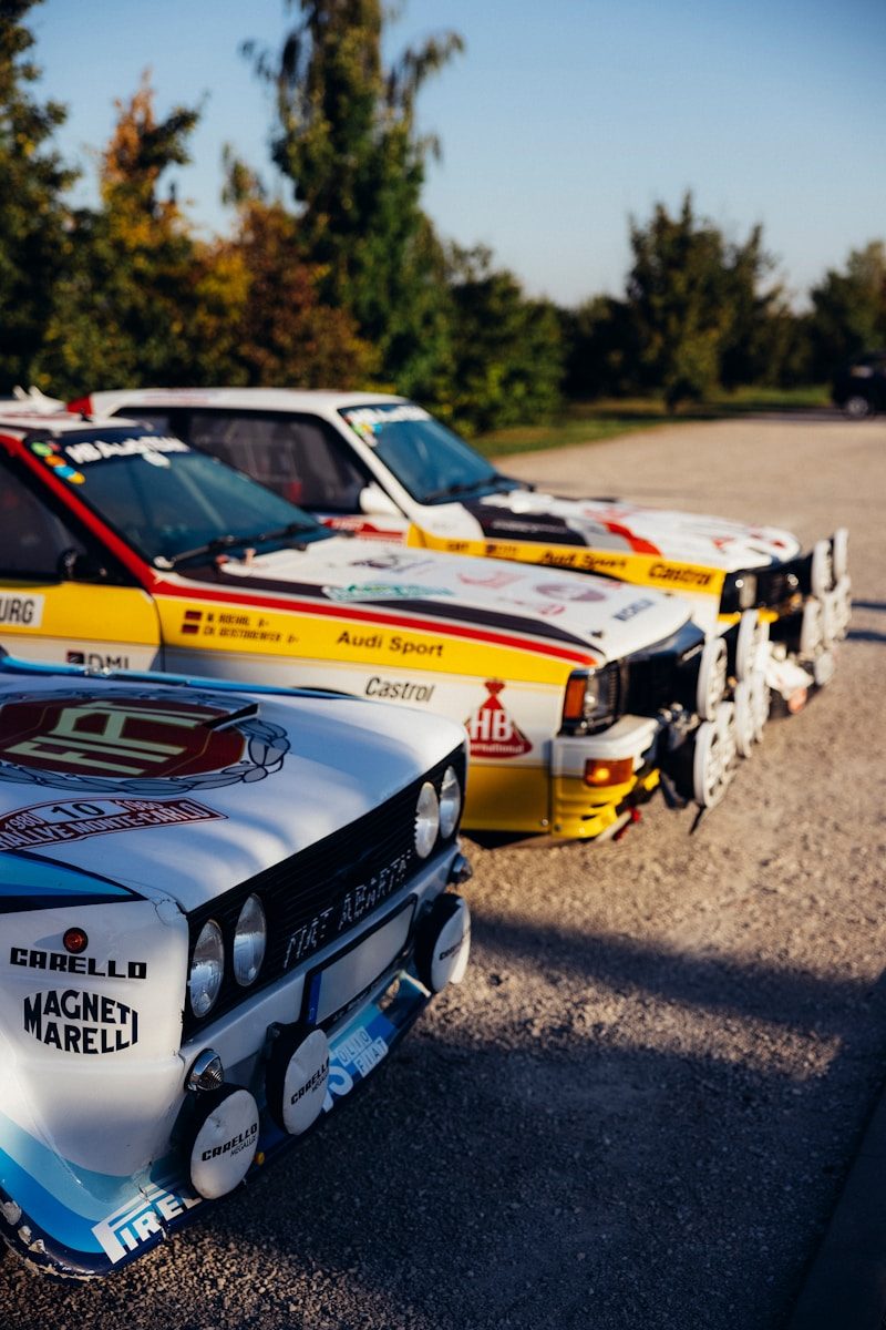 un groupe de voitures de Rallye garées les unes à côté des autres dans un parking.