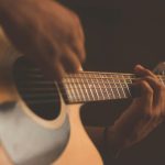 personne apprend à jouer de la guitare