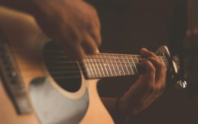personne apprend à jouer de la guitare