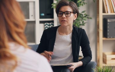 une femme assise sur un canapé en train de former une autre femme avec une formation thérapeute